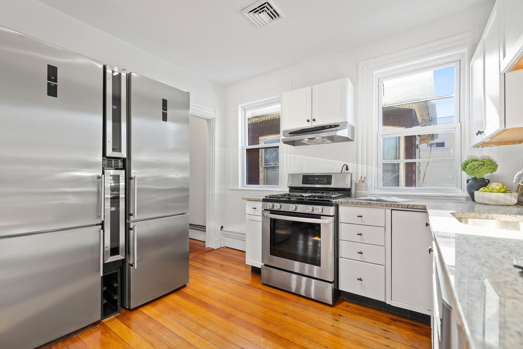112 Franklin Street, Unit 3 Brookline, MA 02445 - Photo 5 of 16 a kitchen with stainless steel appliances granite countertop a refrigerator a stove and a sink