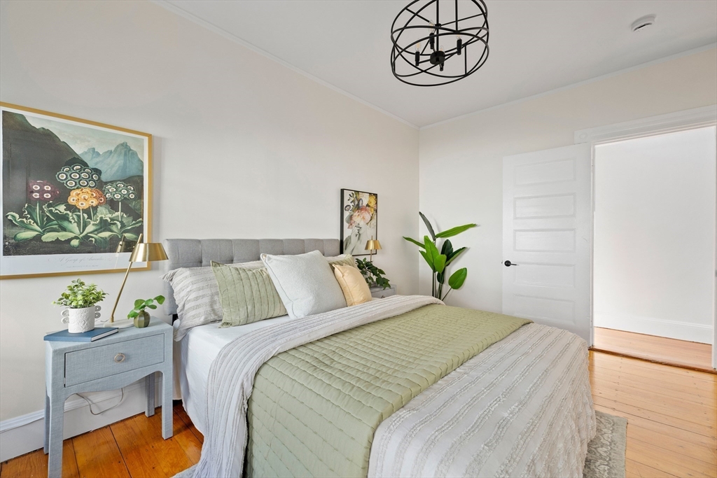 112 Franklin Street, Unit 3 Brookline, MA 02445 - Photo 8 of 16 a bedroom with bed and paintings on the wall