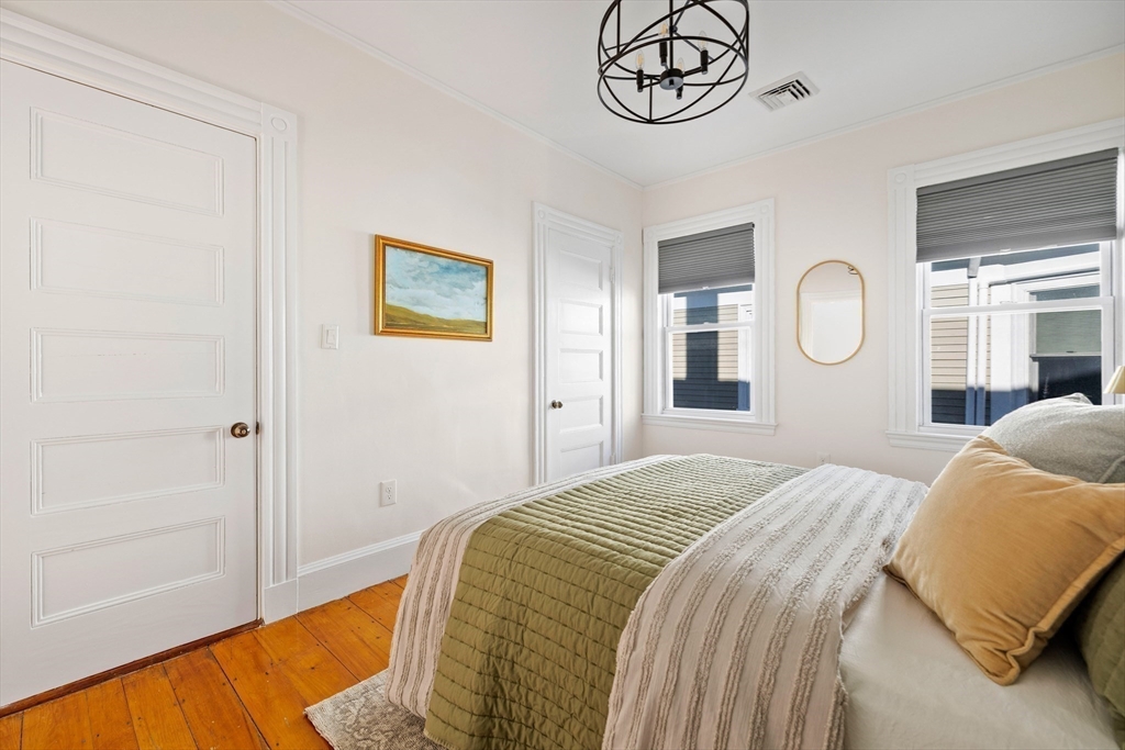 112 Franklin Street, Unit 3 Brookline, MA 02445 - Photo 9 of 16 a bedroom with a bed and a chandelier