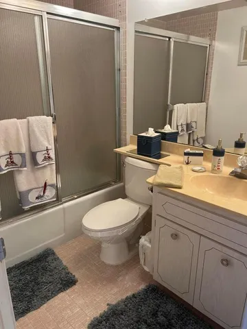 a bathroom with a sink a toilet a mirror and shower
