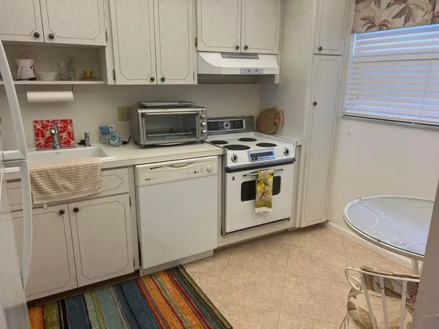 a white stove top oven sitting inside of a kitchen