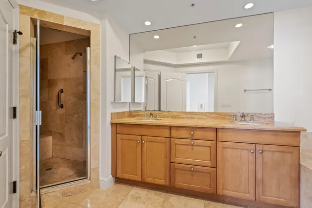 a bathroom with a granite countertop sink mirror and shower