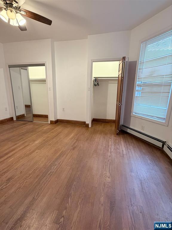 242 Grant Avenue, Unit 2 East Newark, NJ 07029 - Photo 3 of 9 an empty room with wooden floor cabinet and windows
