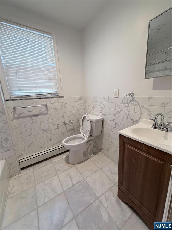 242 Grant Avenue, Unit 2 East Newark, NJ 07029 - Photo 5 of 9 a spacious bathroom with a granite countertop sink a toilet and mirror