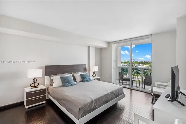 a bedroom with a bed and large windows