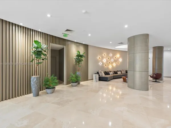 a view of a livingroom with furniture and floor to ceiling window