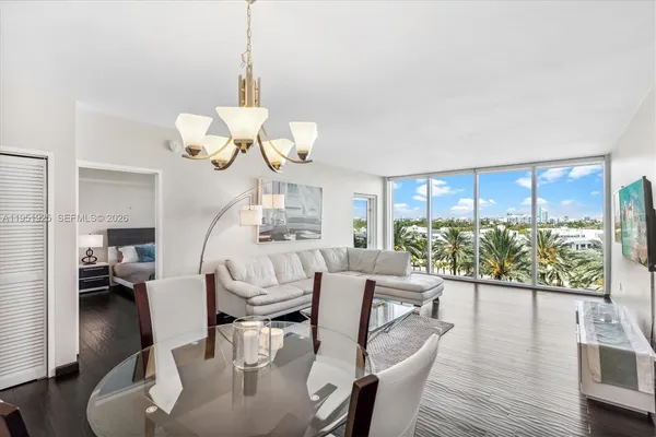 a view of a dining room and livingroom with furniture wooden floor a chandelier