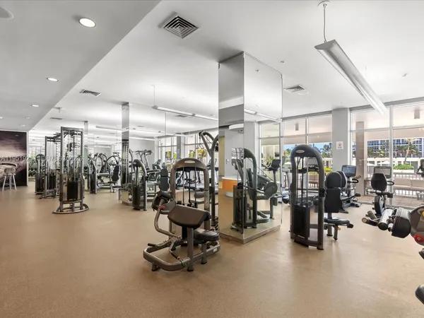 a room with gym equipment and glass door