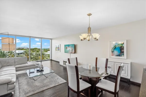 a dining room with furniture a chandelier and wooden floor