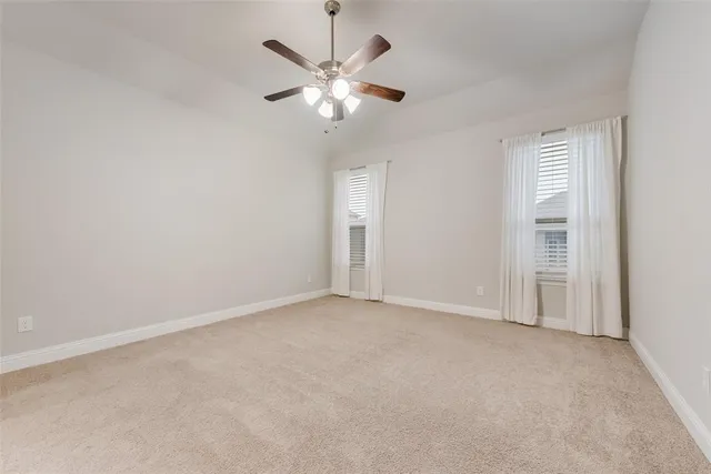 an empty room with chandelier fan