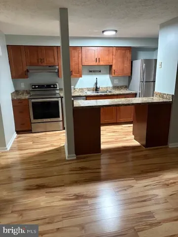 a kitchen with stainless steel appliances kitchen island granite countertop a stove a sink and a microwave