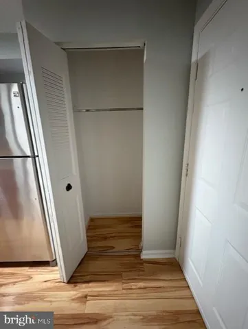 an empty room with wooden floor and entrance