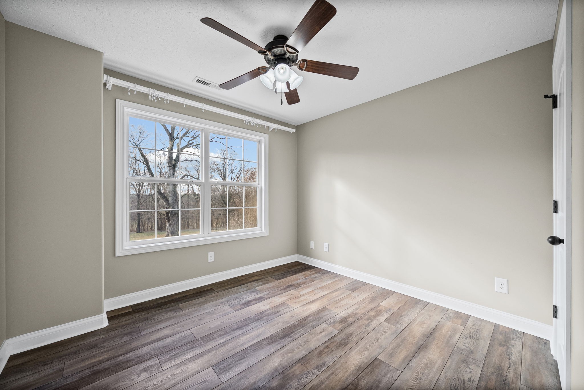 1903 East Boy Scout Road Clarksville, TN 37042 - Photo 26 of 36 a view of an empty room with wooden floor and a window