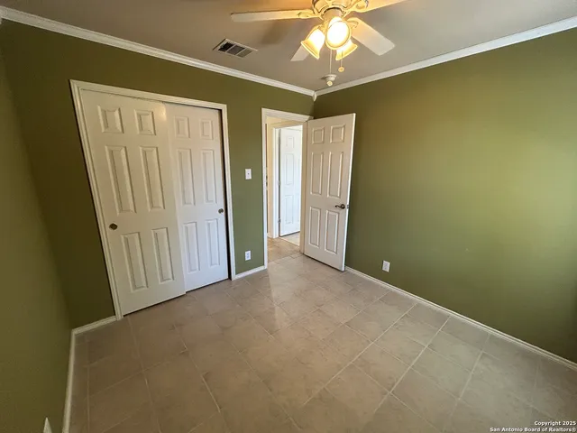 an empty room with a chandelier fan