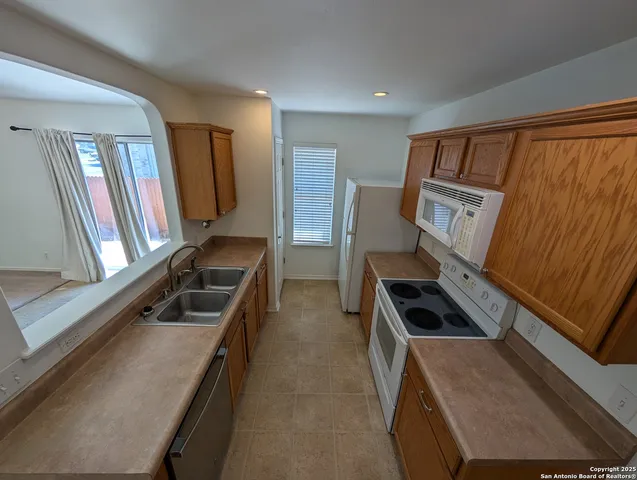 a kitchen with sink refrigerator and window