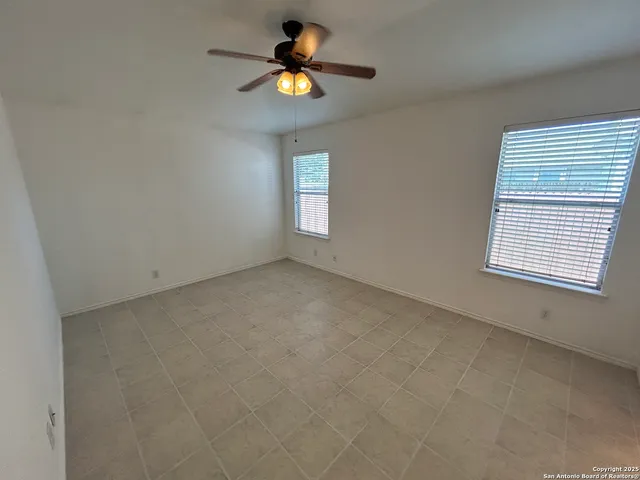 an empty room with a window and a ceiling fan