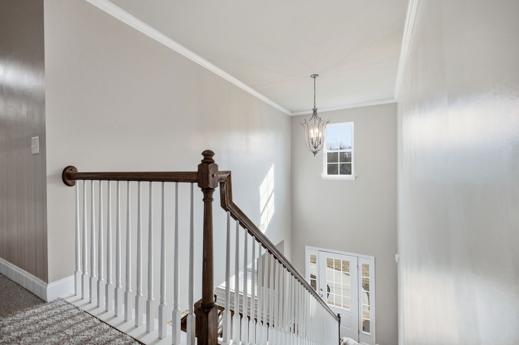 511 Cromer Road Townville, SC 29689 - Photo 28 of 45 Elegant staircase with classic banister and illuminating chandelier.