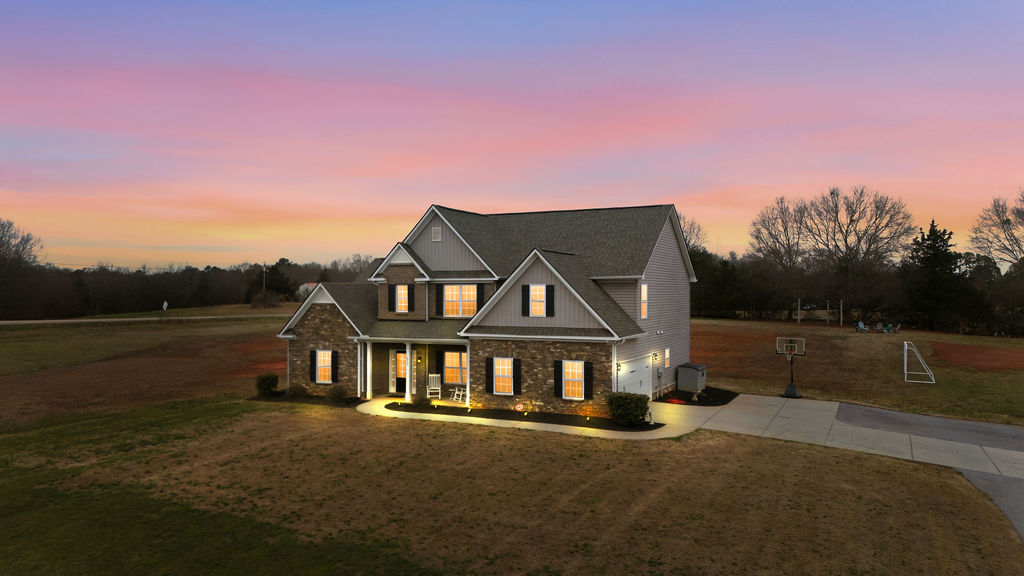 511 Cromer Road Townville, SC 29689 - Photo 44 of 45 This inviting residence features a well-maintained exterior, a driveway, and a welcoming porch at dusk.