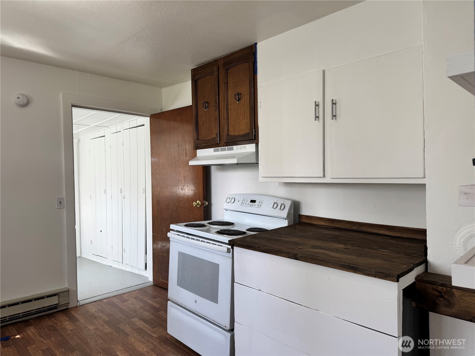 61 North Kean Street Republic, WA 99166 - Photo 16 of 34 a kitchen with granite countertop a stove and a white cabinets
