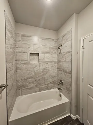 a bathroom with a bathtub and shower