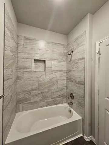 a bathroom with a bathtub and shower