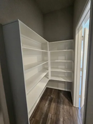 a view of walk in closet with empty racks