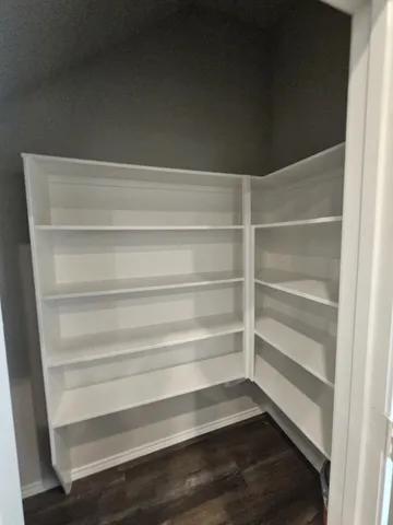 a view of walk in closet with empty racks