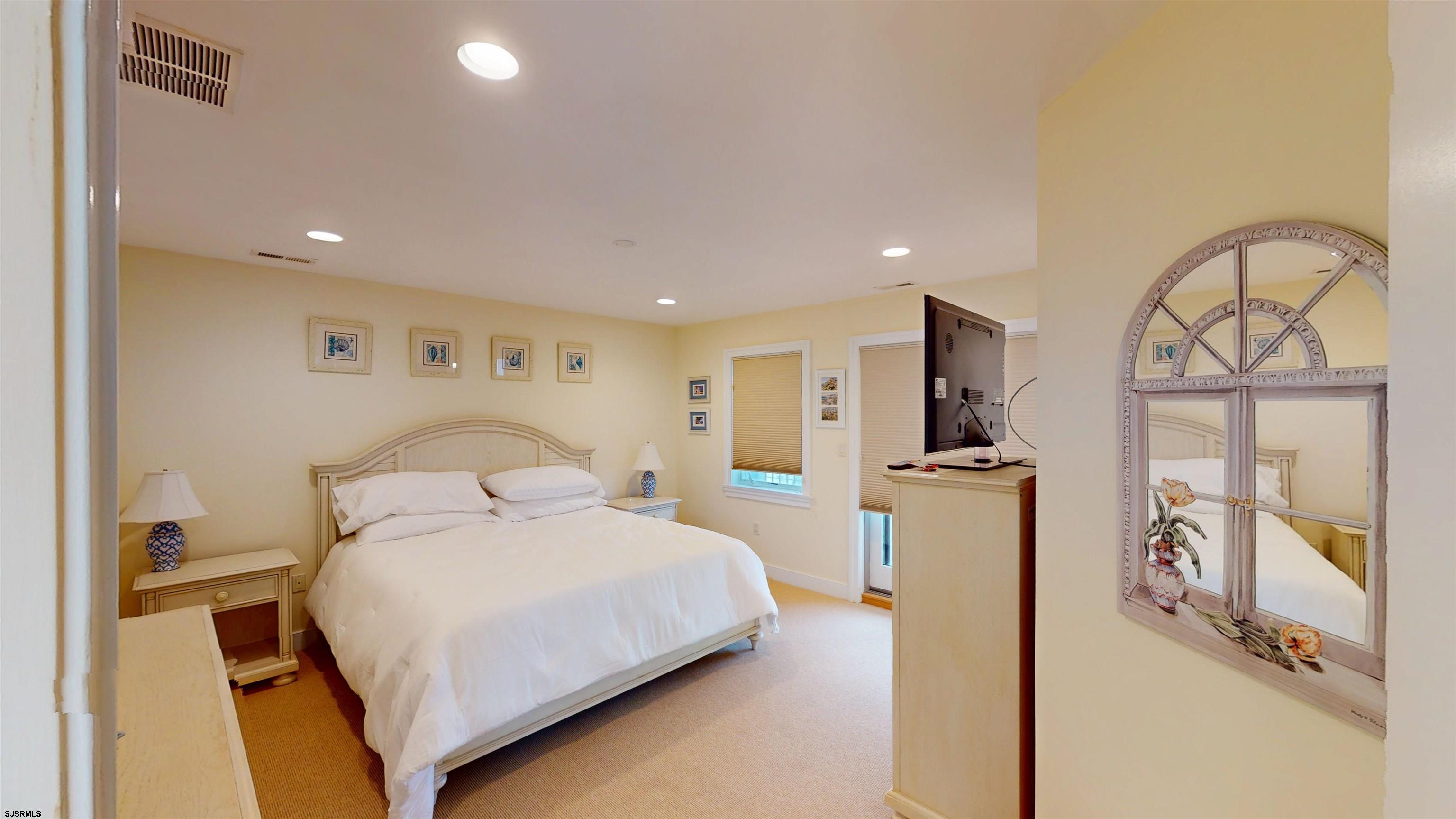 214 North Decatur Avenue, Unit 3B Margate City, NJ 08402 - Photo 23 of 41 a bedroom with a large bed and a chandelier