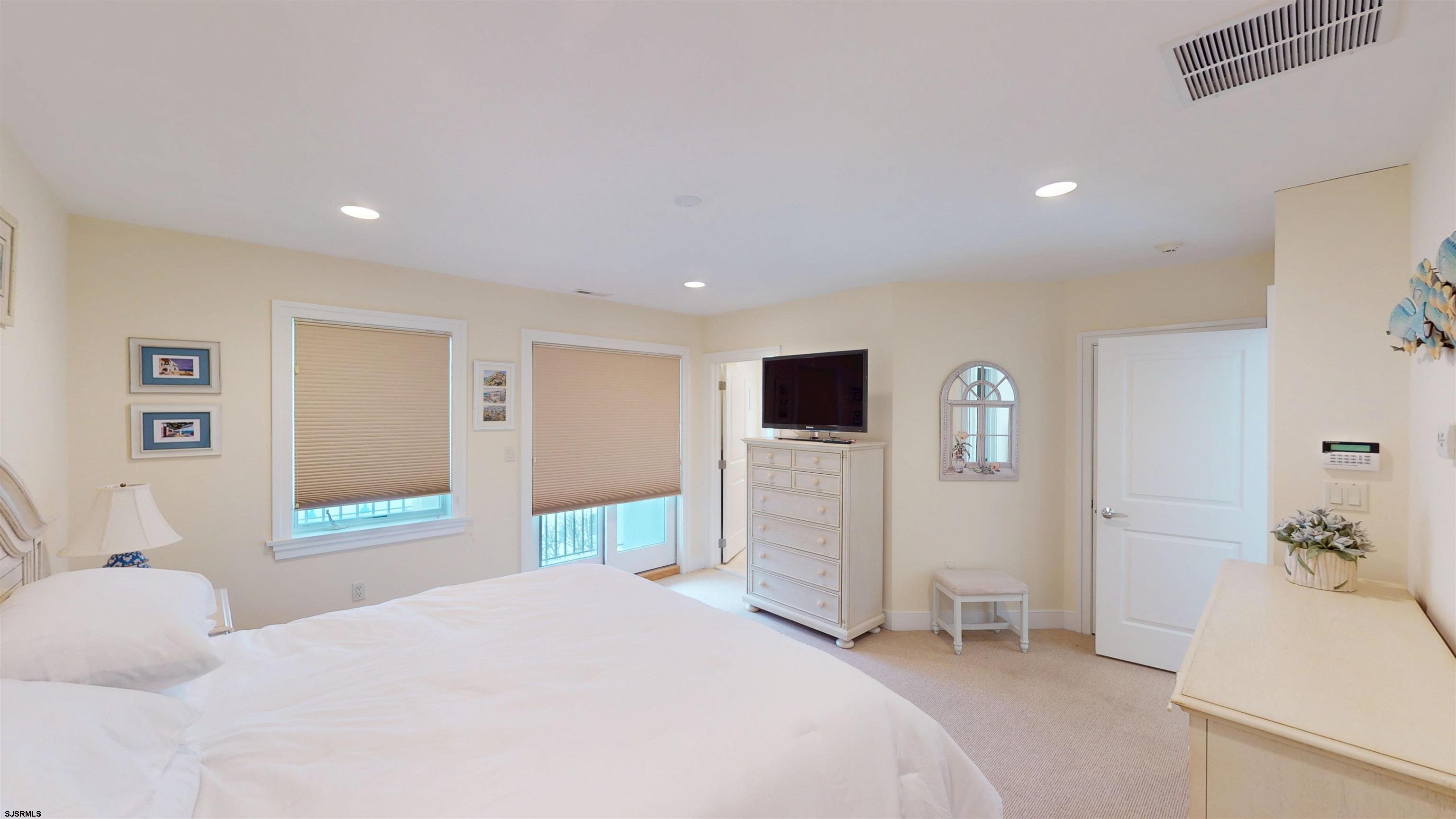 214 North Decatur Avenue, Unit 3B Margate City, NJ 08402 - Photo 25 of 41 a bedroom with a bed and a flat screen tv