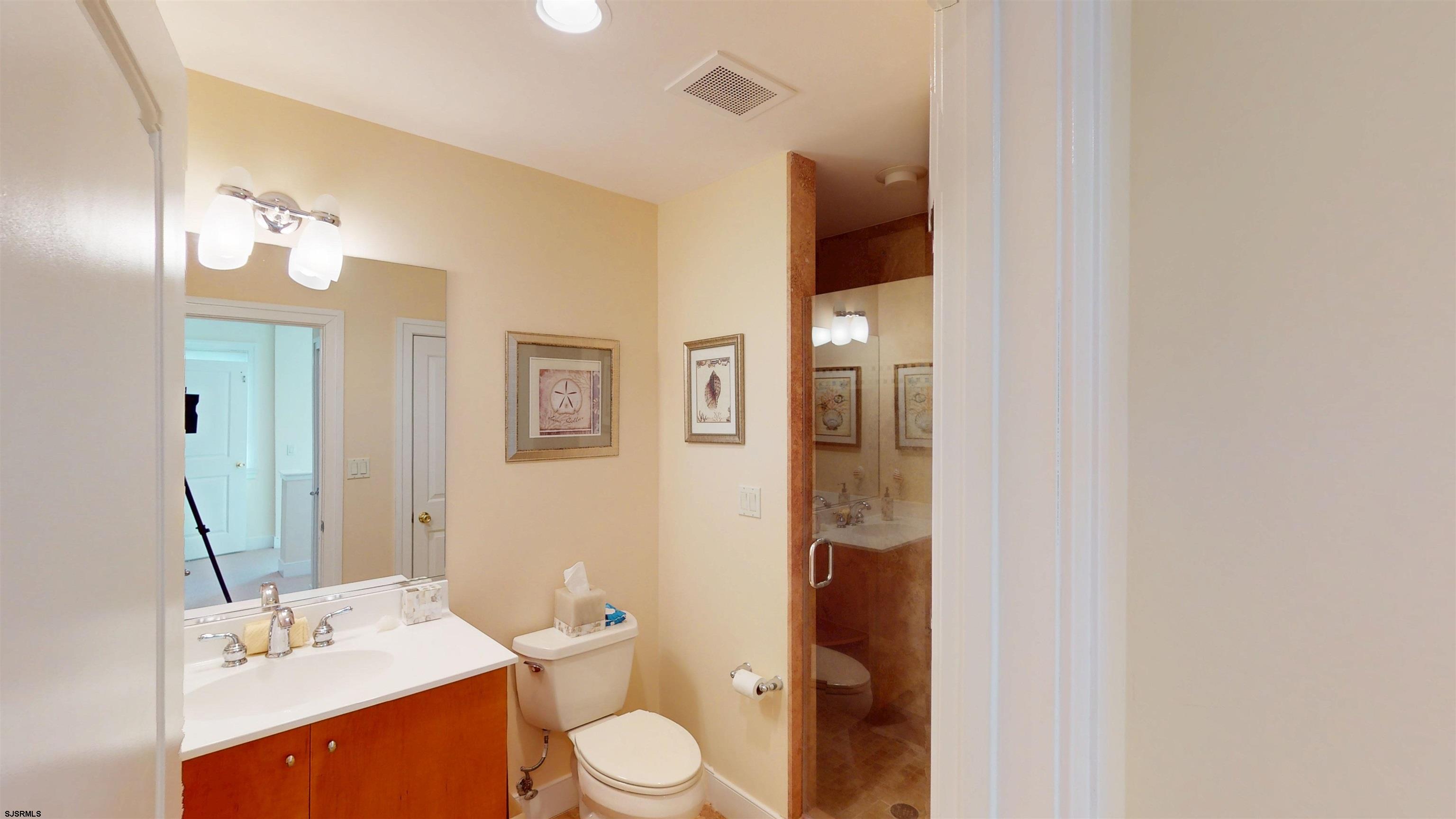 214 North Decatur Avenue, Unit 3B Margate City, NJ 08402 - Photo 30 of 41 a bathroom with a toilet a sink and mirror