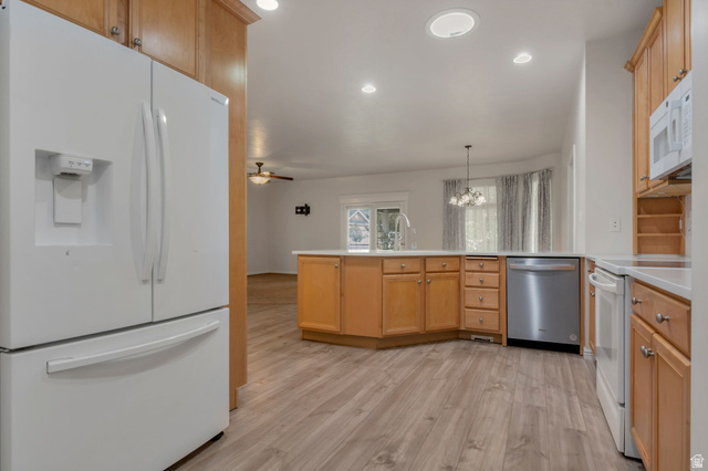1092 Tithing Ridge Drive Riverton, UT 84065 - Photo 3 of 25 Kitchen entry from garage, featuring wood-finish flooring, recessed lighting, and a center island with sink and integrated dishwasher