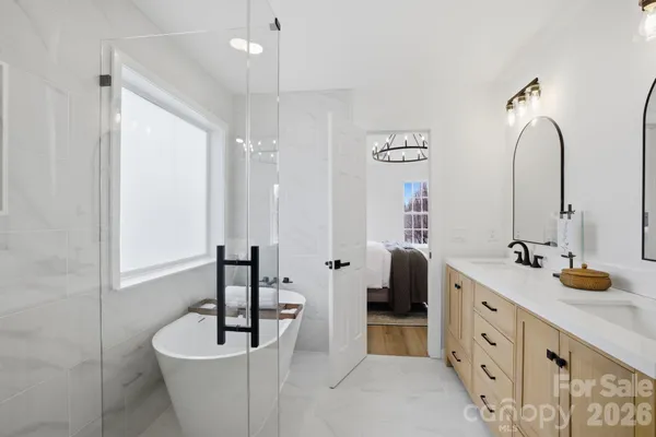 a bathroom with a double vanity sink a mirror a bathtub and shower