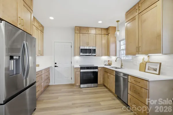 a kitchen with stainless steel appliances a refrigerator sink and stove