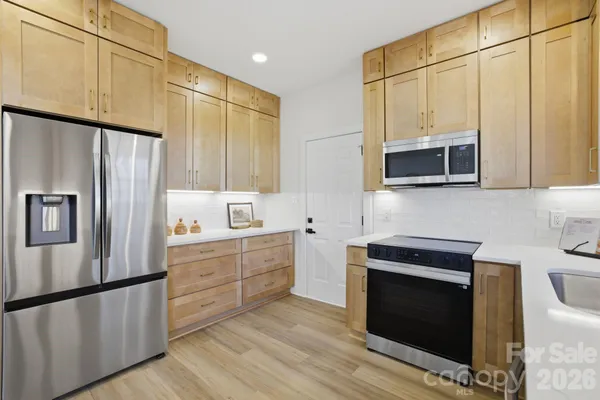 a kitchen with stainless steel appliances a stove microwave and refrigerator