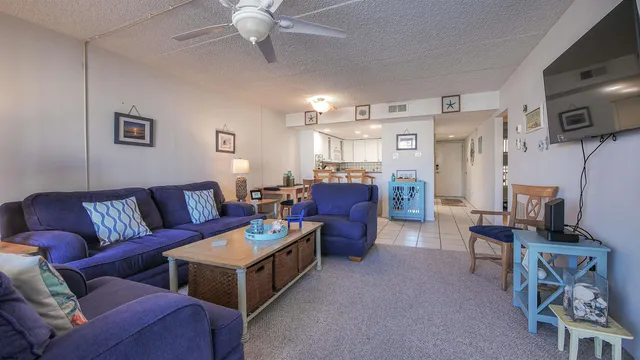 a living room with furniture a flat screen tv and a window