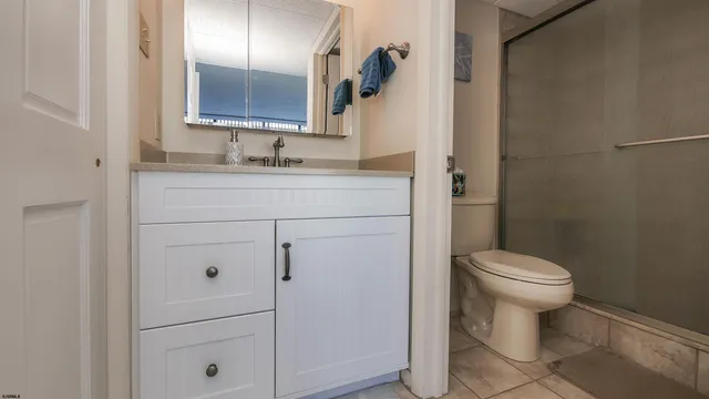 a bathroom with a toilet sink vanity and mirror