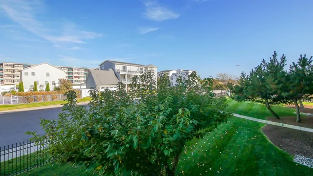 a view of a city with tall buildings in middle of green field