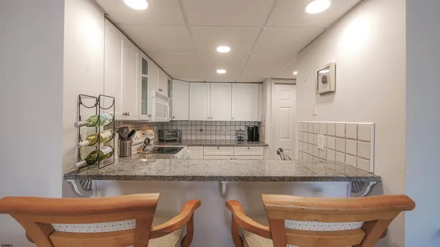 a kitchen with a table chairs sink and cabinets