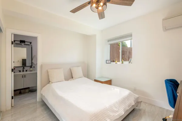 a bedroom with a large bed and a chandelier
