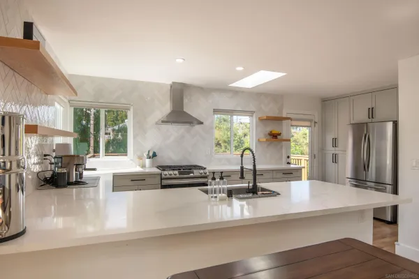 a kitchen with kitchen island a counter top a stove and a sink