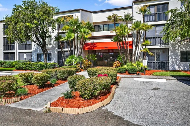 a view of a house with a yard and potted plants
