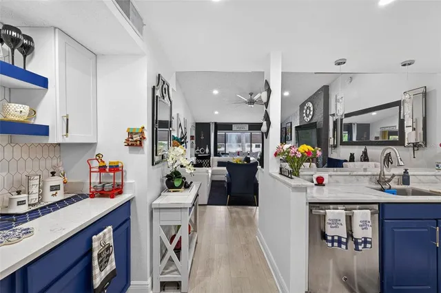 a view of a kitchen with stainless steel appliances granite countertop a sink dishwasher and cabinets with wooden floor