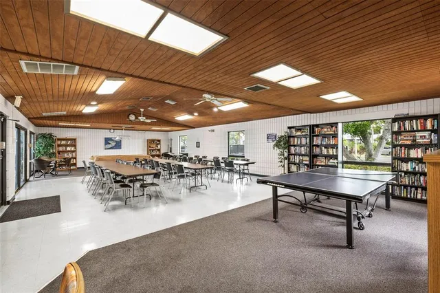 a kitchen with stainless steel appliances granite countertop a table chairs refrigerator and microwave