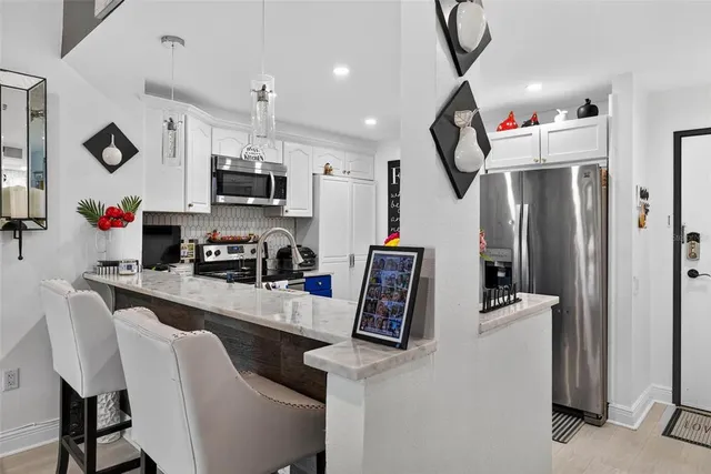 a kitchen with kitchen island a refrigerator stove and microwave