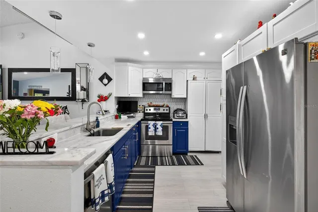 a kitchen with stainless steel appliances granite countertop a refrigerator stove and sink