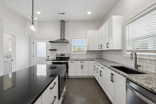 a kitchen with a stove a refrigerator and a sink
