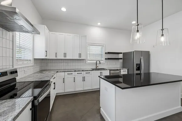 a kitchen with stainless steel appliances granite countertop a sink stove and cabinets