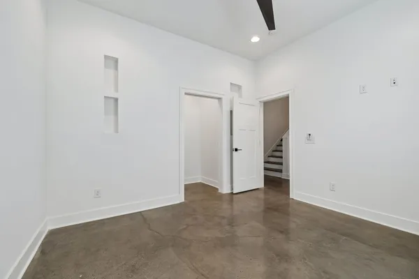 an empty room with a window and a fan