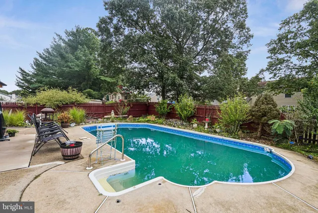 a view of a swimming pool with lawn chairs under an umbrella