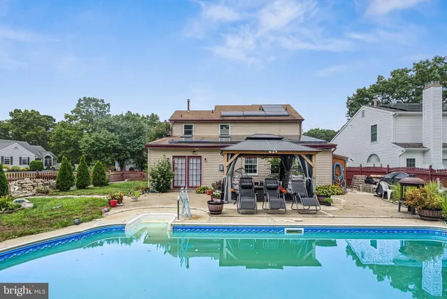 a view of a swimming pool with outdoor seating and a garden